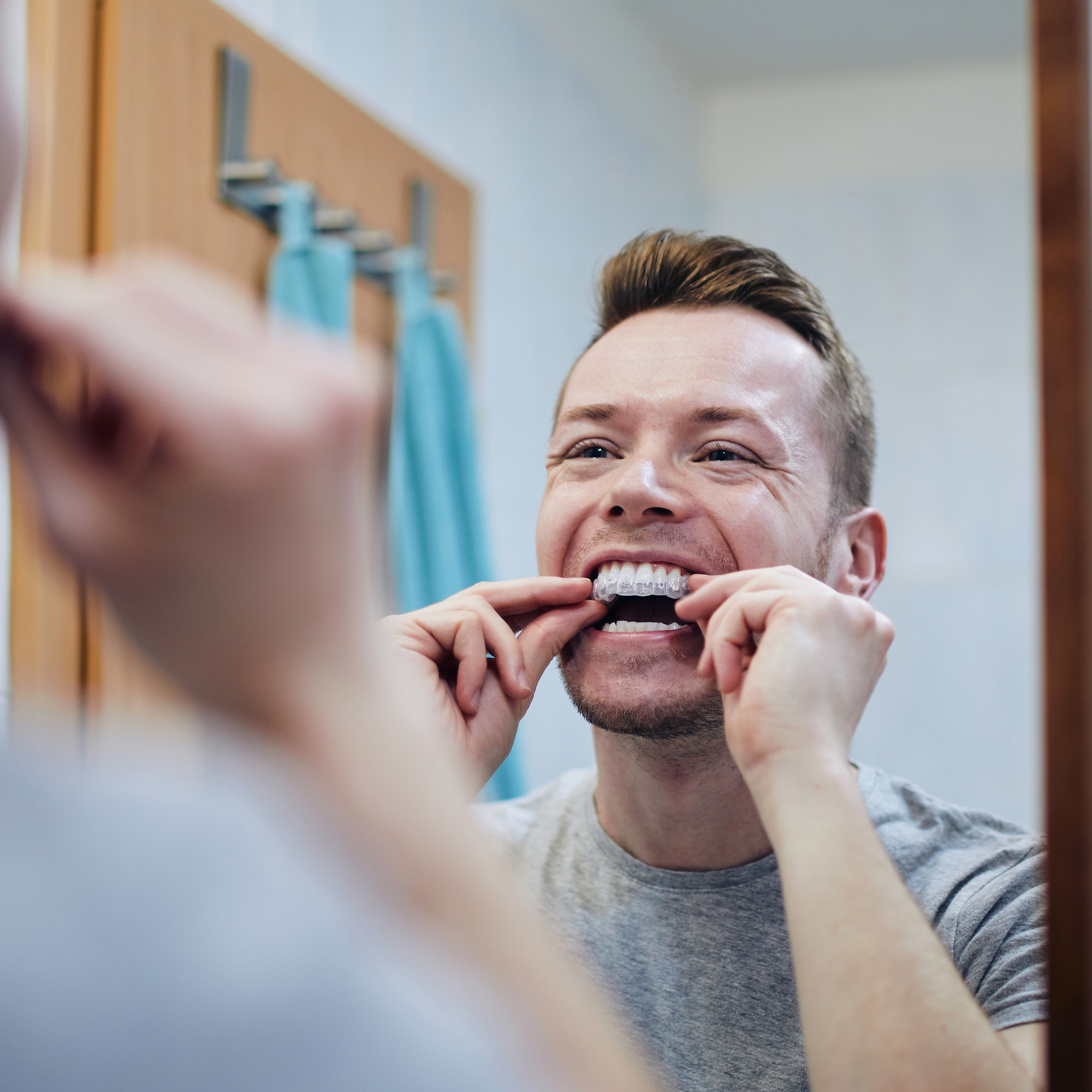 Man preparing silicon tray for teeth whitening.