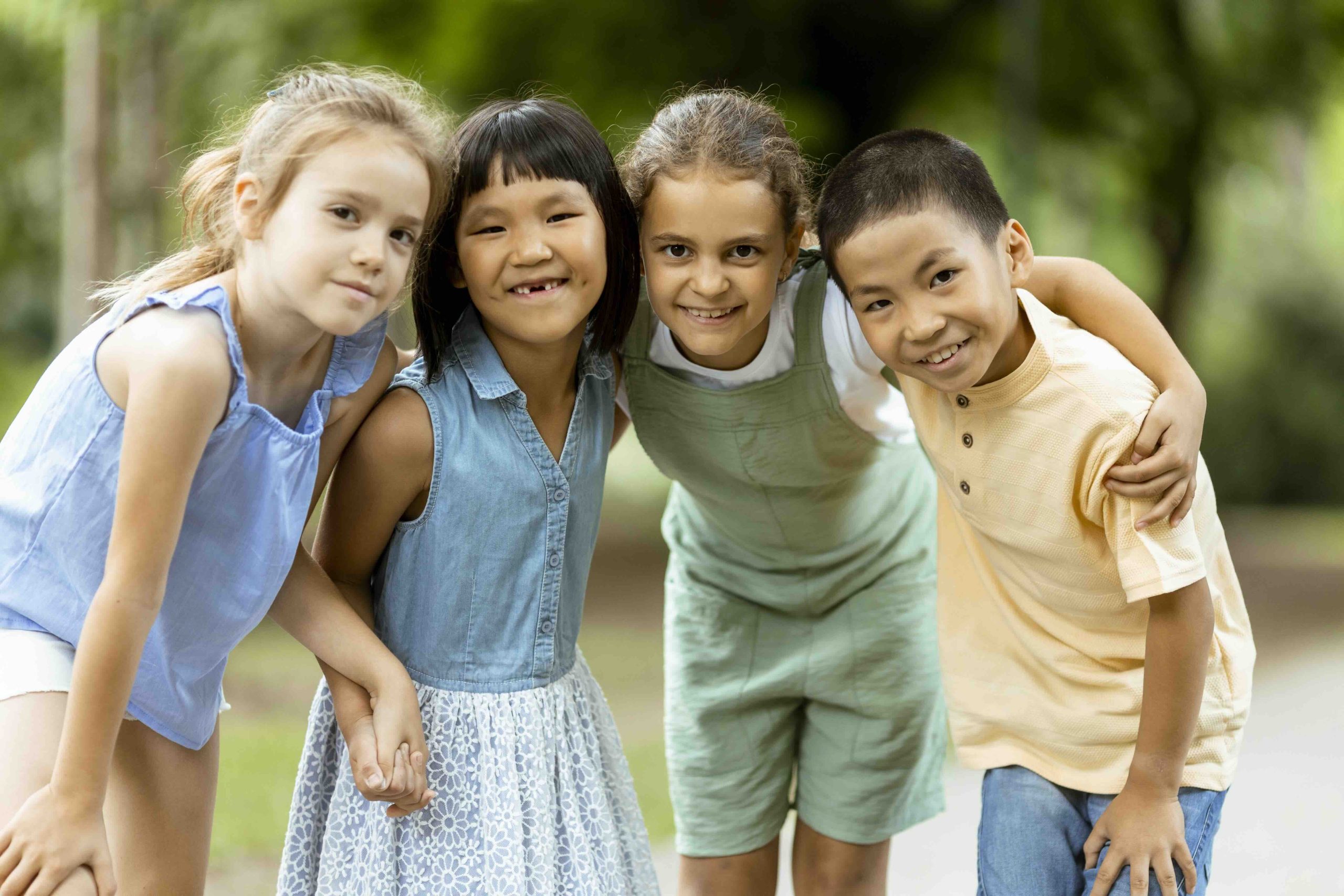 group of 4 diverse children smiling and missing some baby teeth for Tooth Fairy Traditions From Around the World